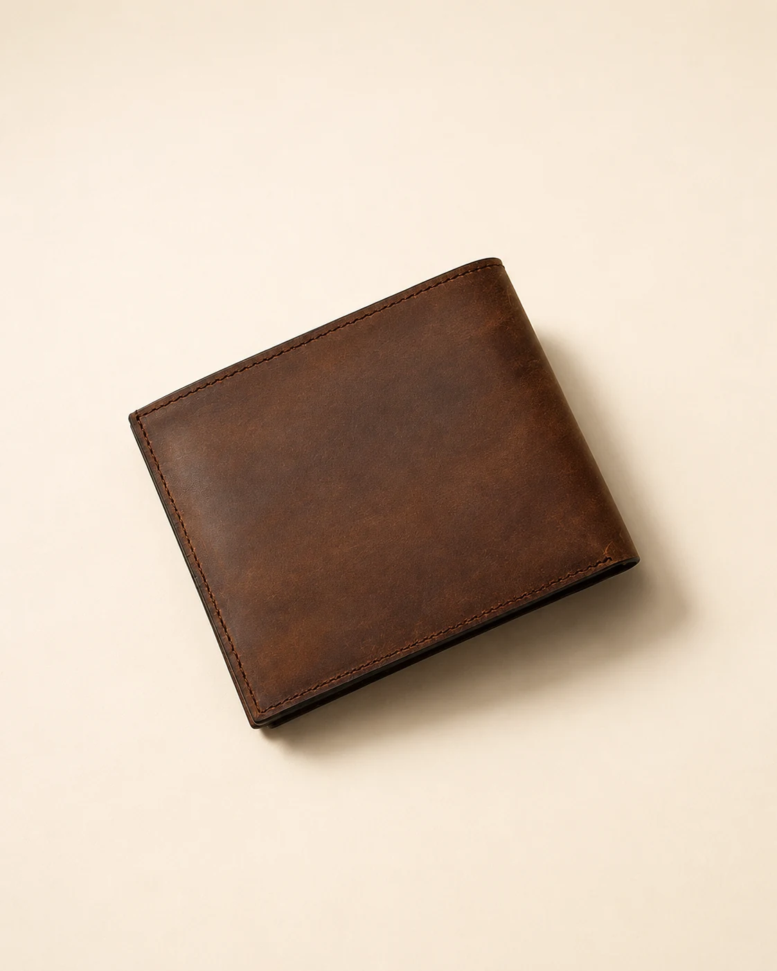 Closed brown leather bifold wallet with tonal stitching
